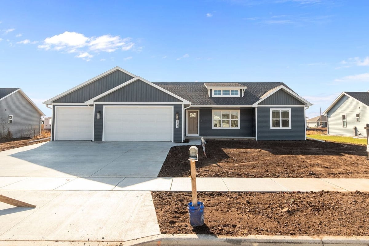 Front view of a newly built ranch-style home with two-car garage and fresh landscaping, located in the Fox Cities