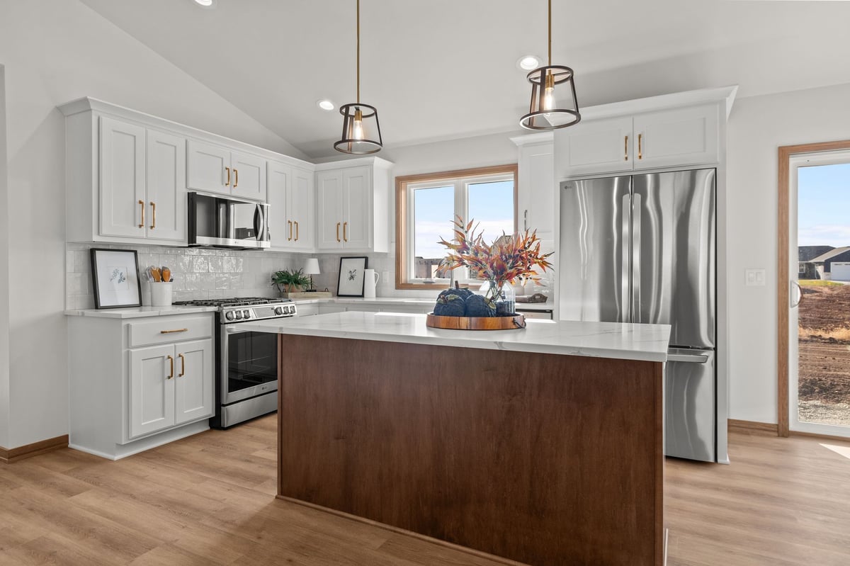 Bright kitchen with white cabinets, wood island, stainless appliances, and pendant lighting, located in the Fox Cities