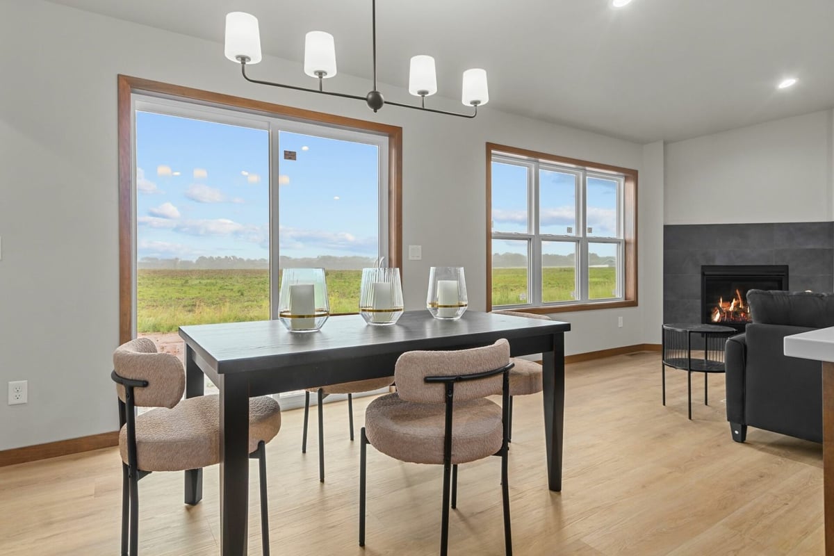 Custom dining area with large windows and modern chandelier in a Midwest Design Homes project in Kaukauna, WI