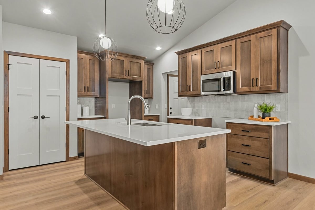 Custom kitchen featuring sleek countertops and warm finishes by Midwest Design Homes in Fremont, WI