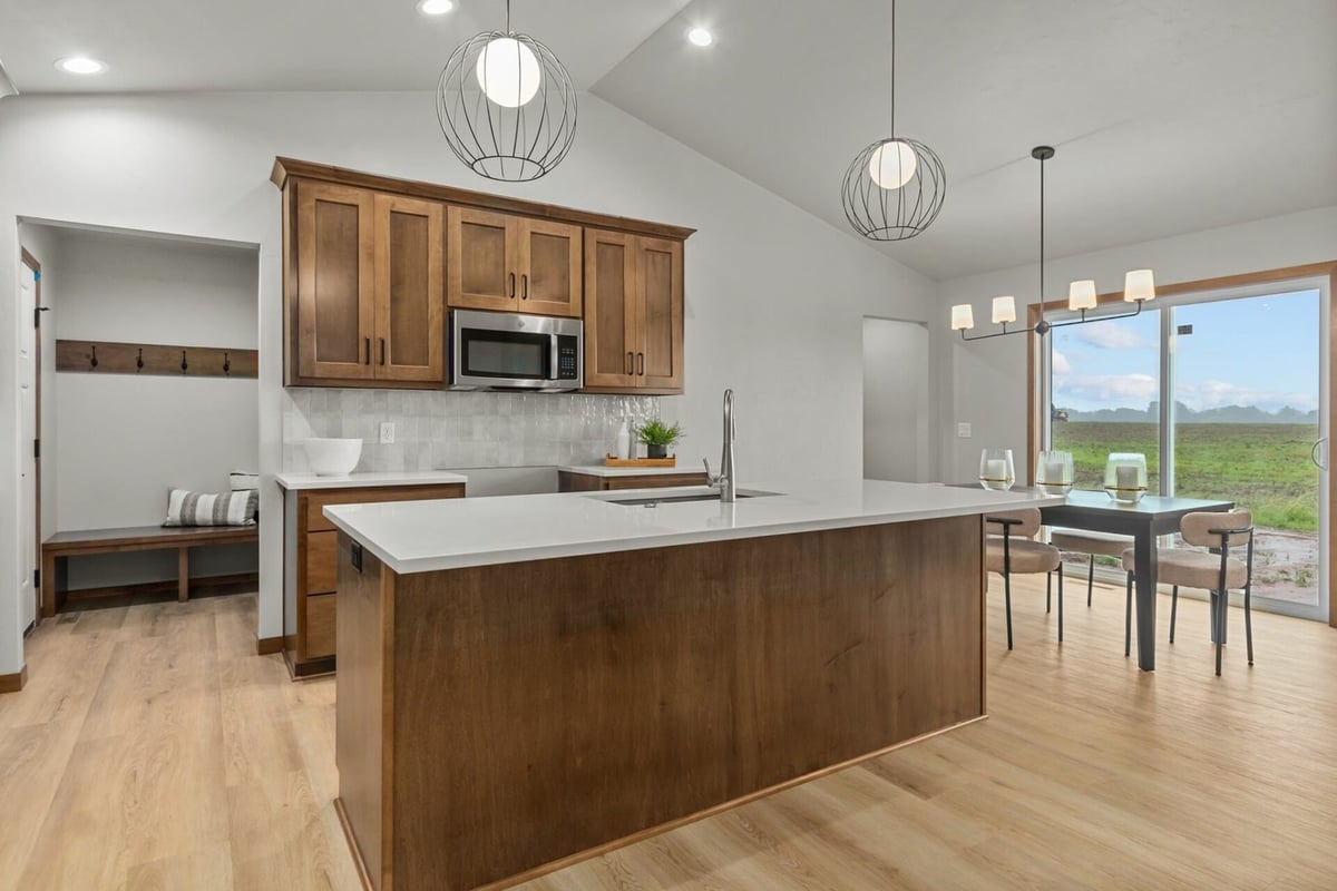 Kitchen island with pendant lights and dining area in custom home by Midwest Design Homes in Lawrence, WI