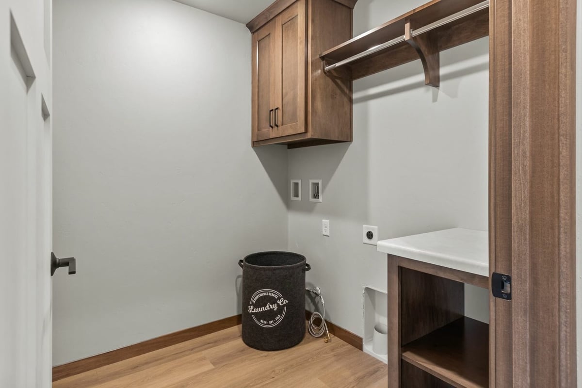 Laundry room with wood cabinetry and washerdryer hookups in a custom home by Midwest Design Homes in Fremont, WI