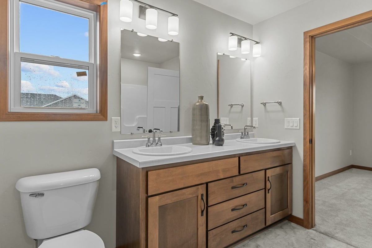 Master bathroom with dual sinks and bright window in a custom home by Midwest Design Homes in Ellington, WI