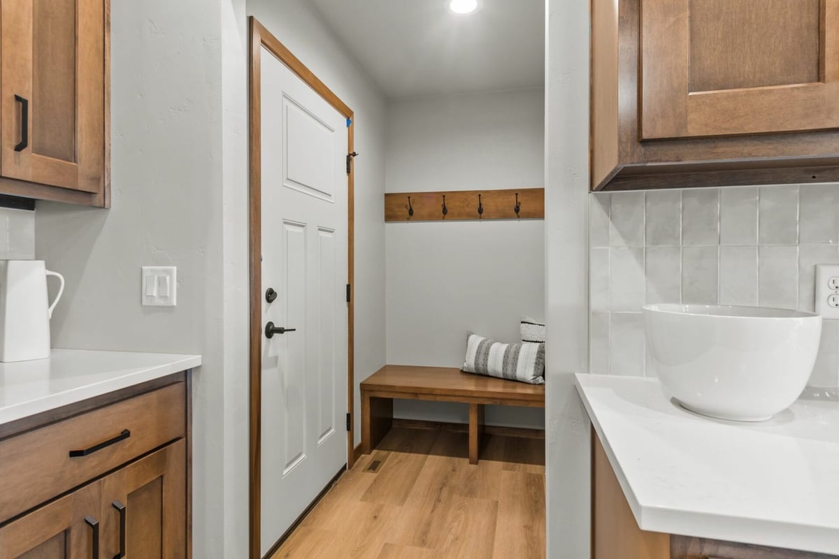 Side entry mudroom with bench and hooks in custom home by Midwest Design Homes in Neenah, WI