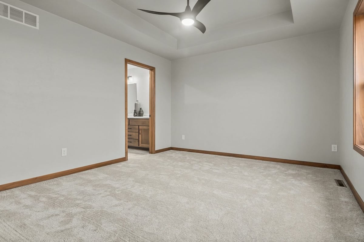 Spacious bedroom featuring white panel doors and soft flooring by Midwest Design Homes in Ledgeview, WI