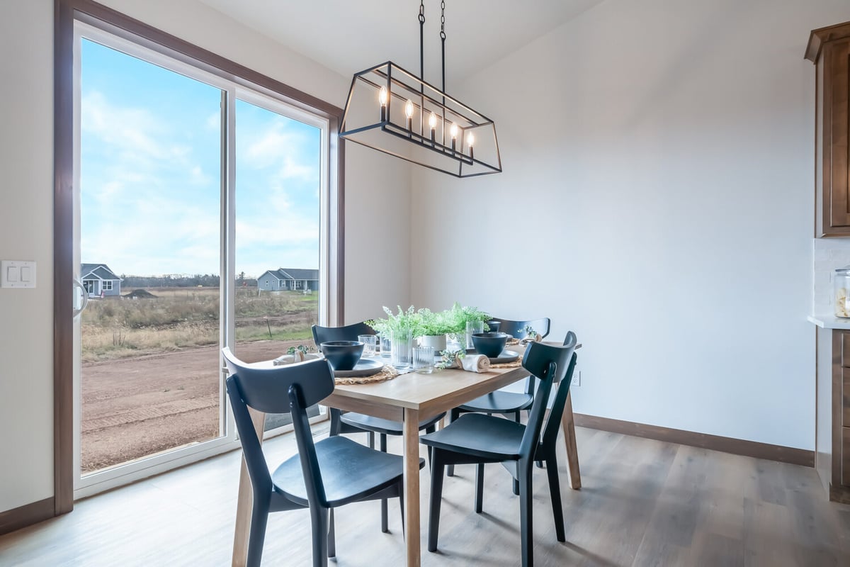 Dining area with natural light and modern chandelier in a Kaukauna, WI custom home by Midwest Design Homes
