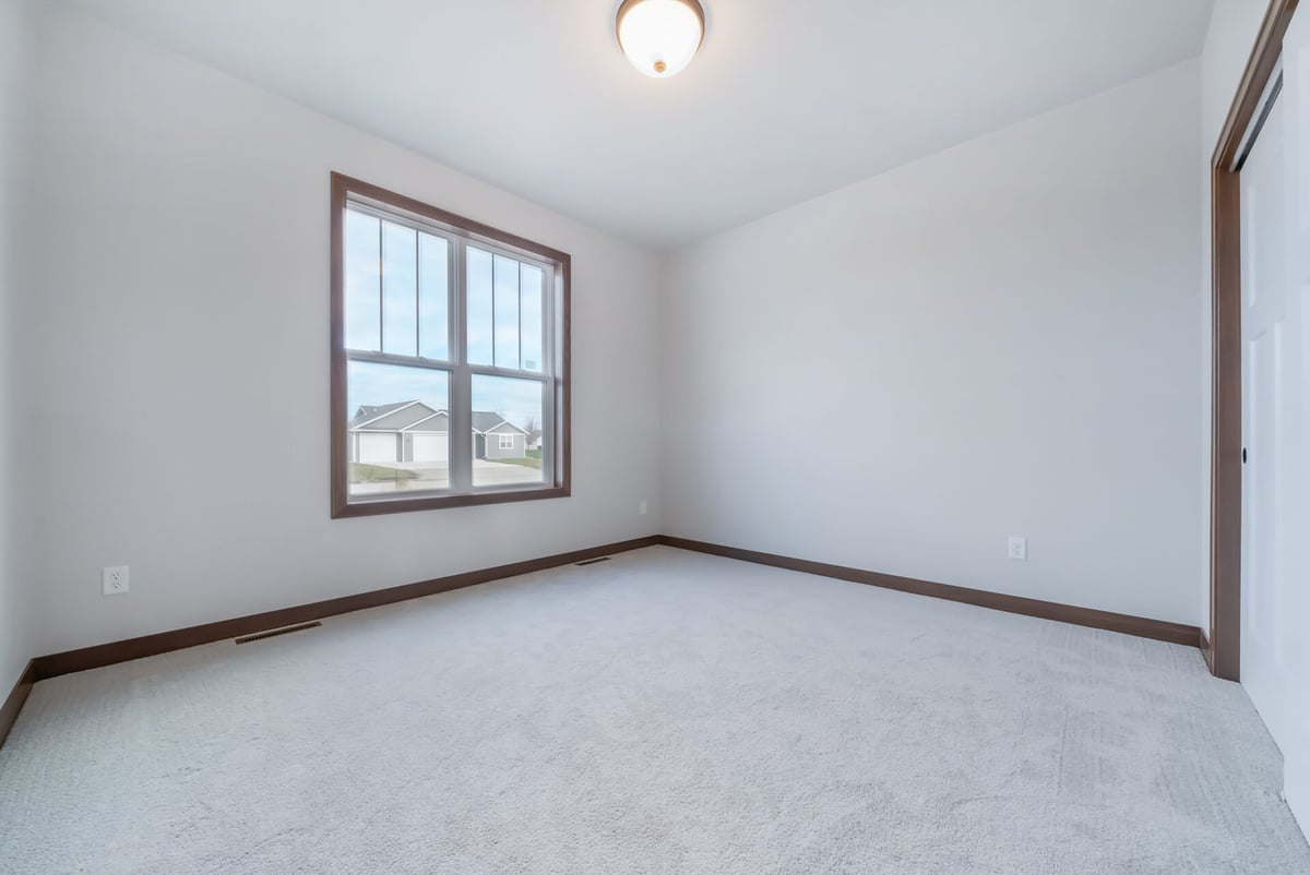 Empty bedroom with large window and natural light in Midwest Design Homes custom home in Appleton, WI