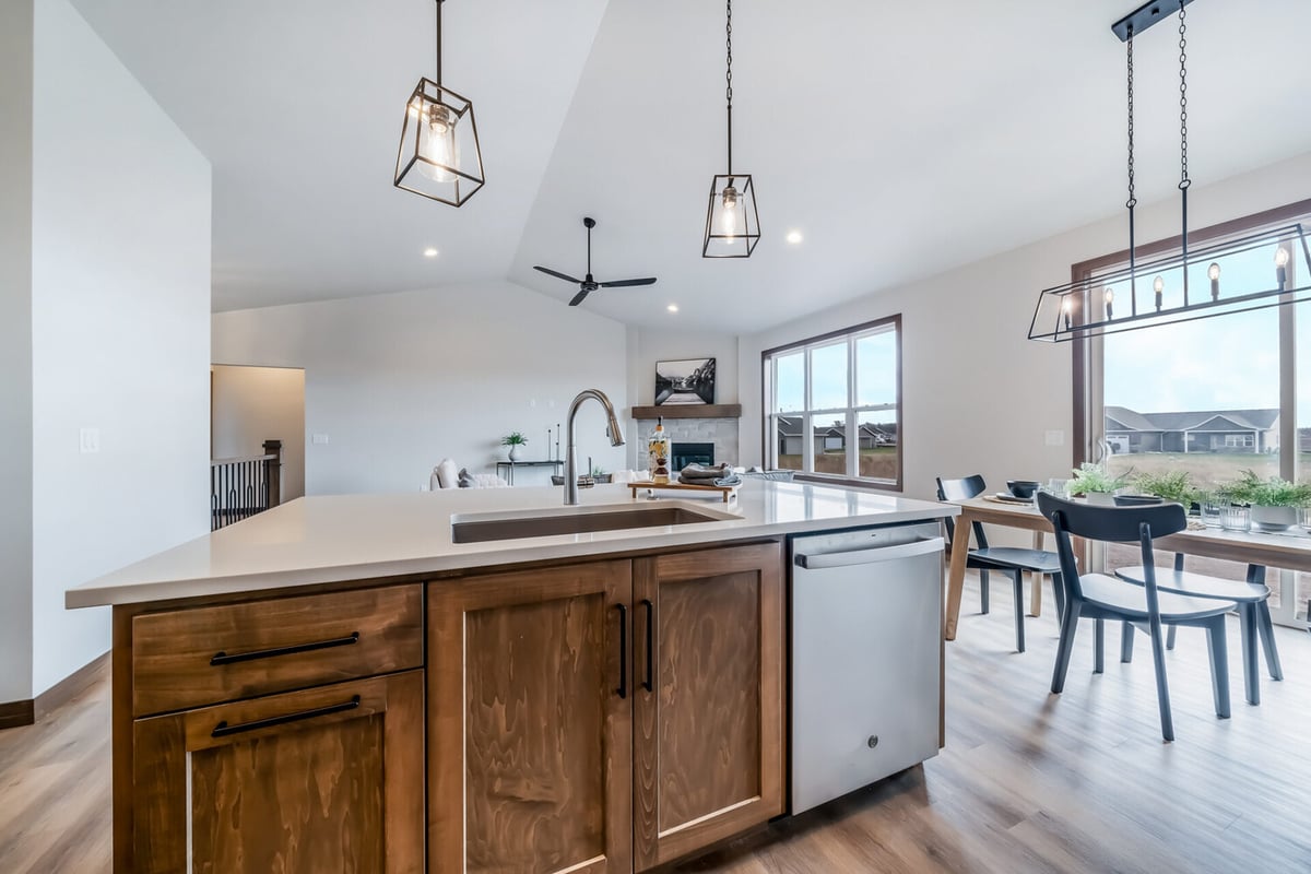 Kitchen island with pendant lights and seating area in a custom Midwest Design Homes build in Kaukauna, WI