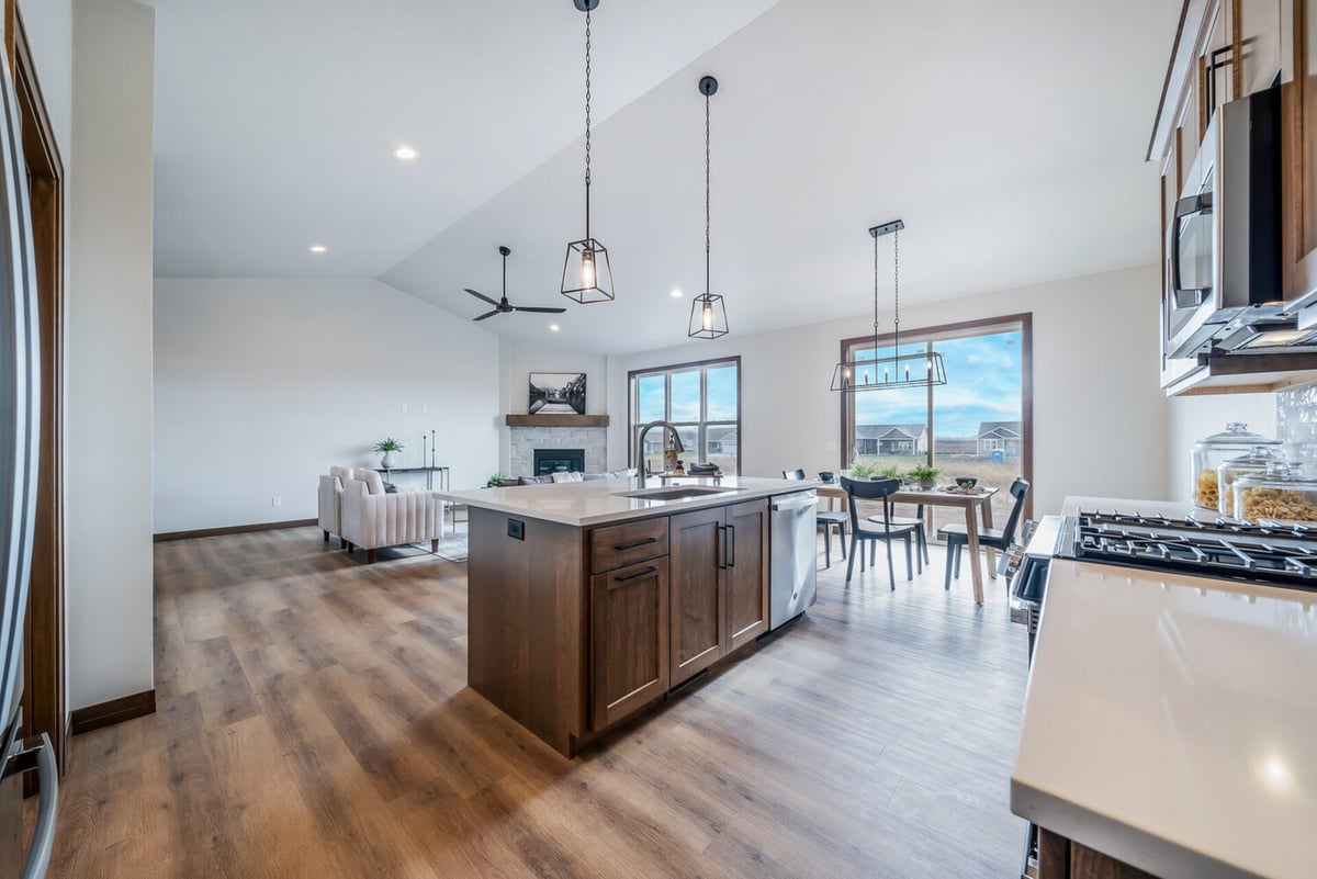 Wide-angle view of kitchen island and great room in a Midwest Design Homes custom home in Kaukauna, WI