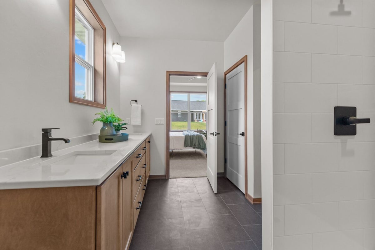 Bathroom with dual vanity and dark tile flooring in a custom home by Midwest Design Homes in Neenah, WI