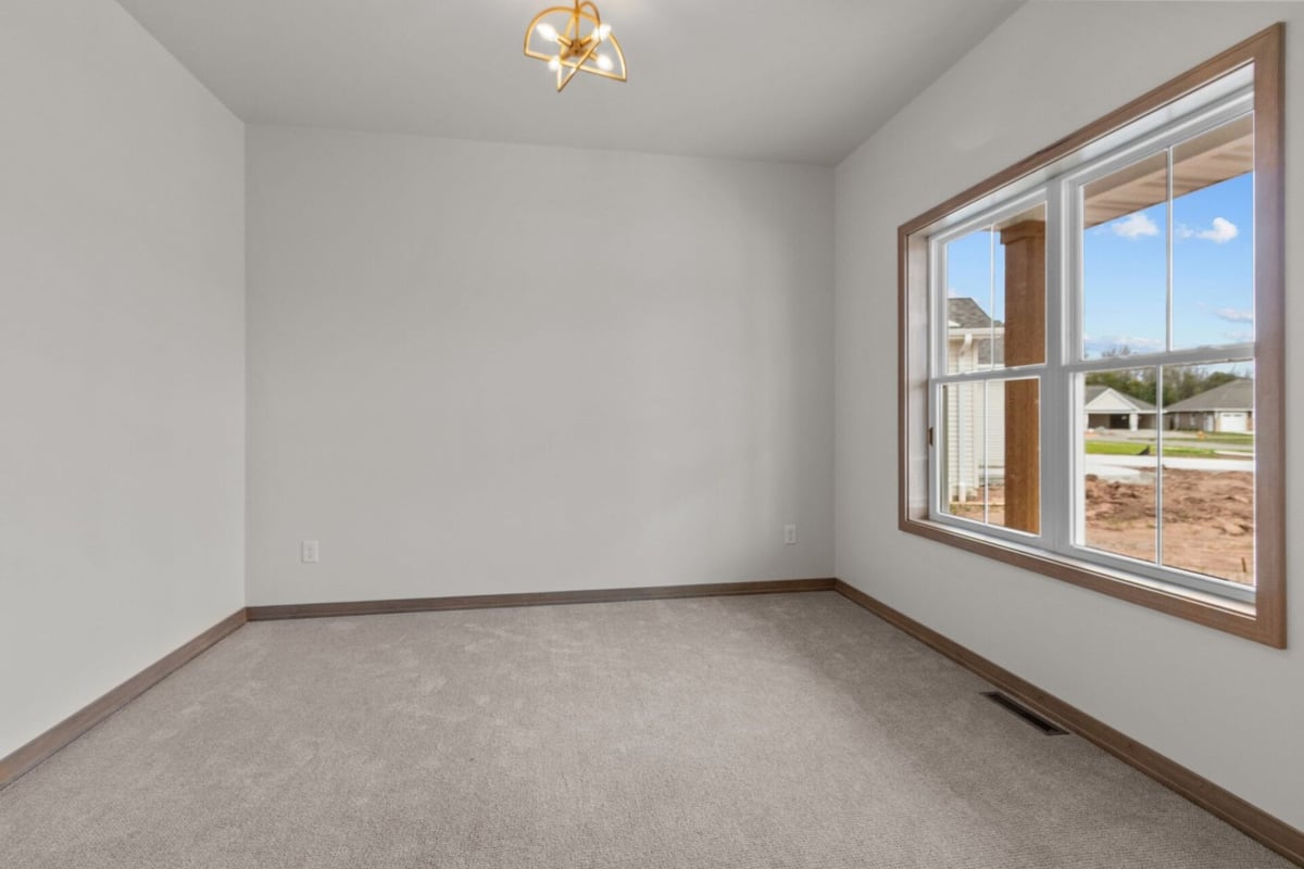 Carpeted front office or flex room with large window in a custom home by Midwest Design Homes in Kaukauna, WI