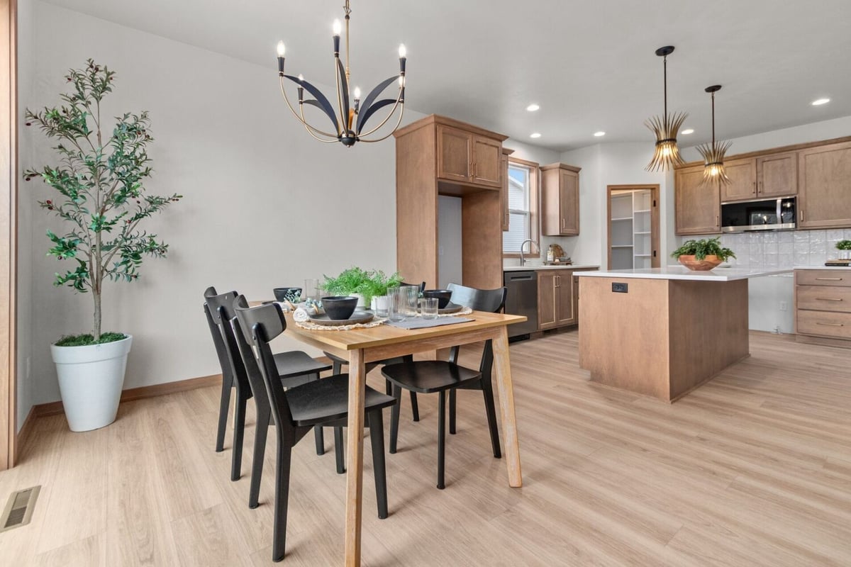 Dining room with black chairs and natural lighting in a custom home by Midwest Design Homes in Bellevue, WI