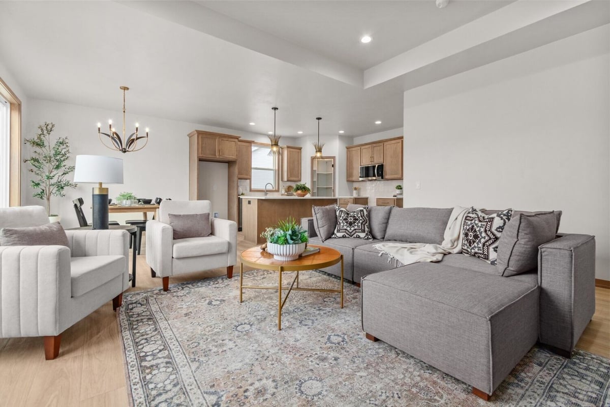 Family room with large sectional and open kitchen view in a custom home by Midwest Design Homes in Fremont, WI