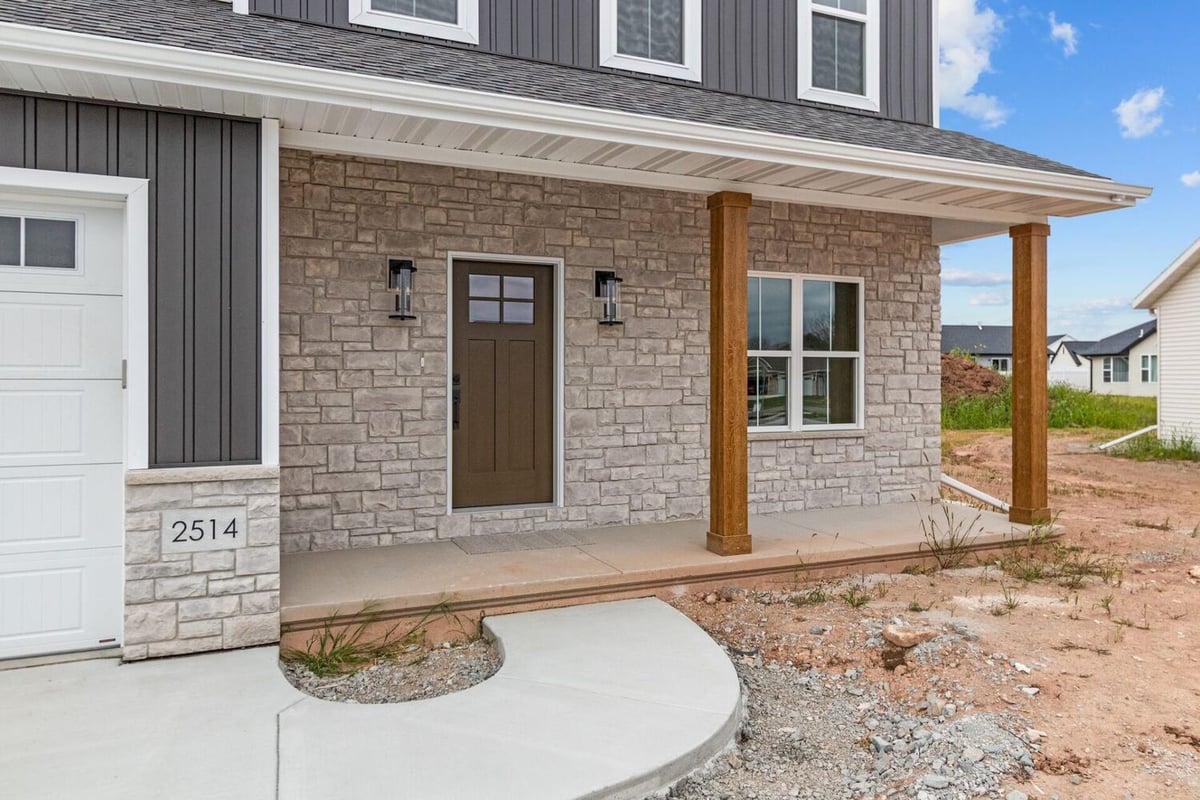 Front entry with stone façade and wood columns in a custom home by Midwest Design Homes in Kaukauna, WI