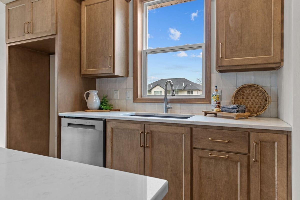Kitchen sink with natural light and wood cabinetry in a custom home by Midwest Design Homes in Neenah, WI.
