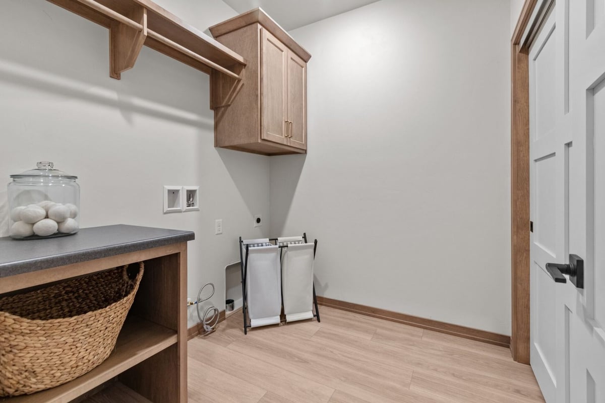 Laundry room with upper cabinets and folding station in a Kaukauna, WI custom home by Midwest Design Homes