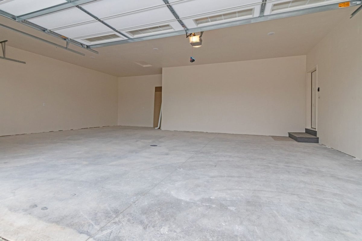 New construction garage with white walls and raised step entry in a Green Bay, WI custom home by Midwest Design Homes
