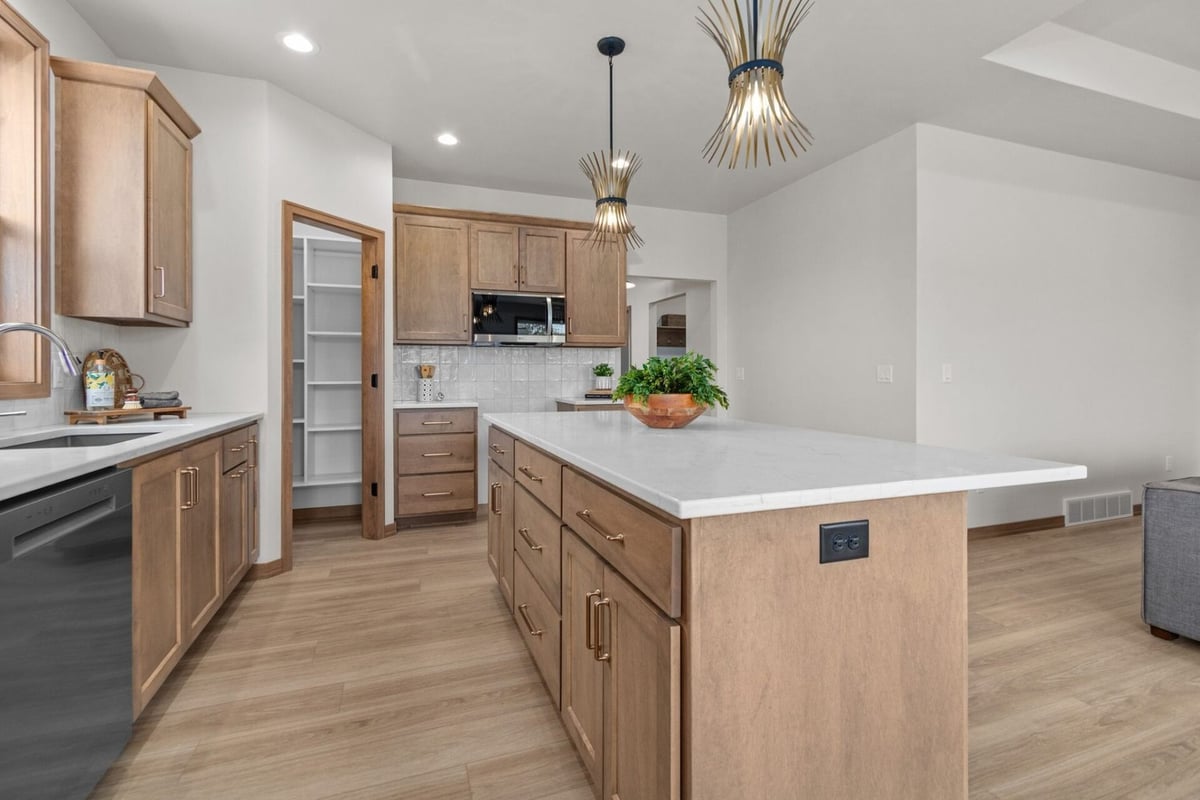 Spacious kitchen with large island and modern pendant lights in a Kaukauna, WI custom home by Midwest Design Homes