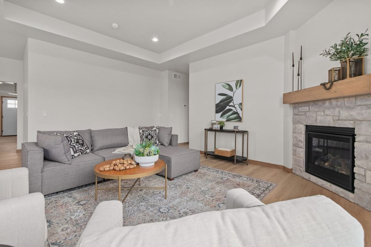 Stylish living room with gray sectional and fireplace in a Midwest Design Homes custom build in Green Bay, WI