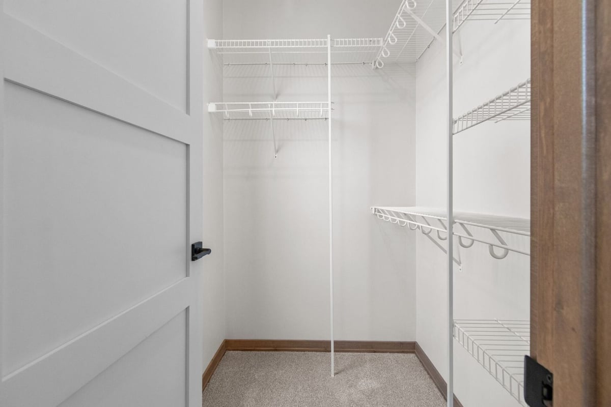 Walk-in closet with white wire shelving in a custom home by Midwest Design Homes in Harrison, WI