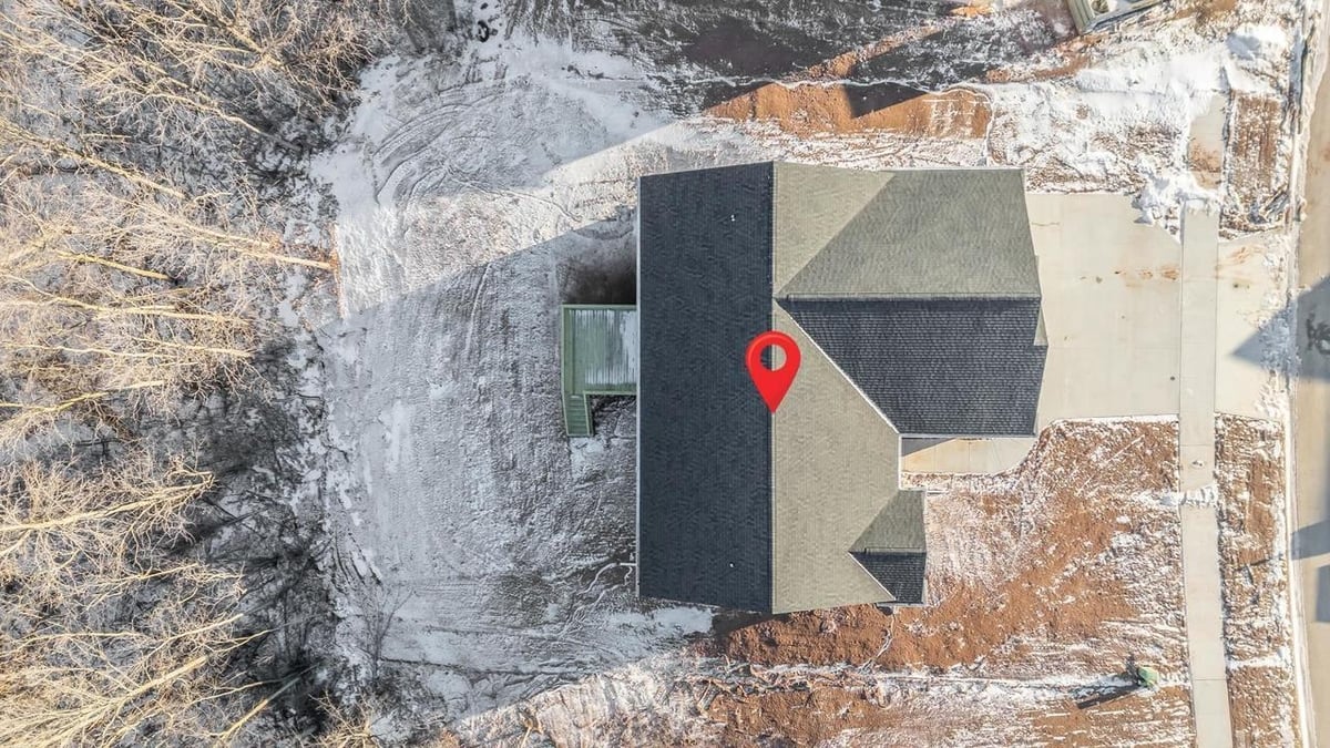 Aerial view of roof and snowy yard with location pin at Fox Cities home