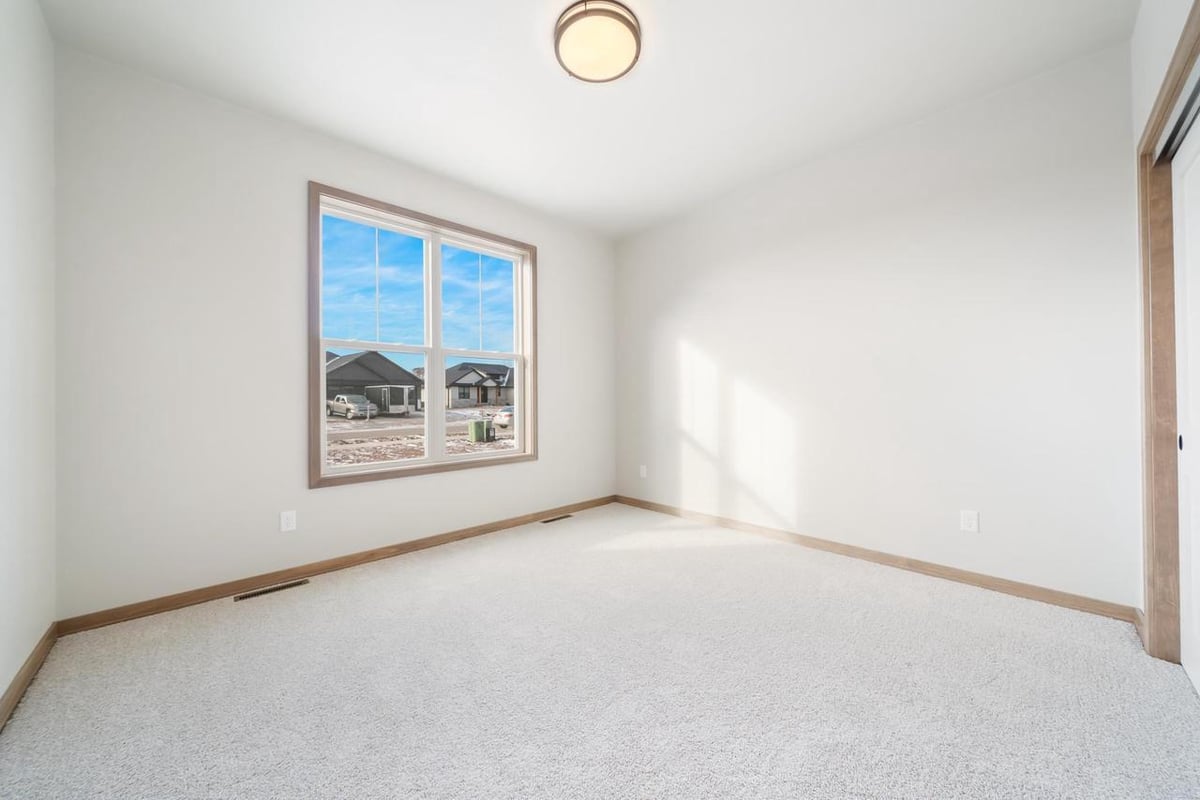 Bright bedroom with large window and plush carpet in the Fox Cities