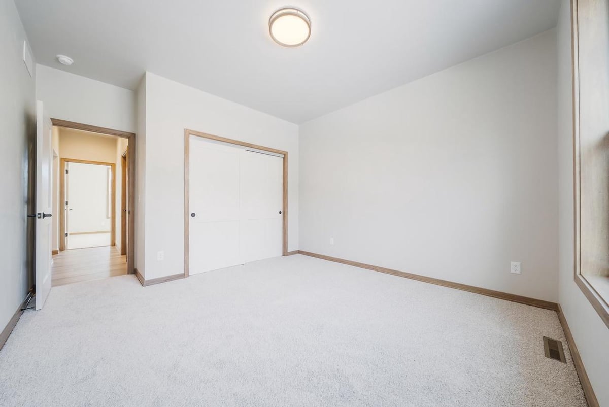 Carpeted bedroom with closet and hall access in the Fox Cities