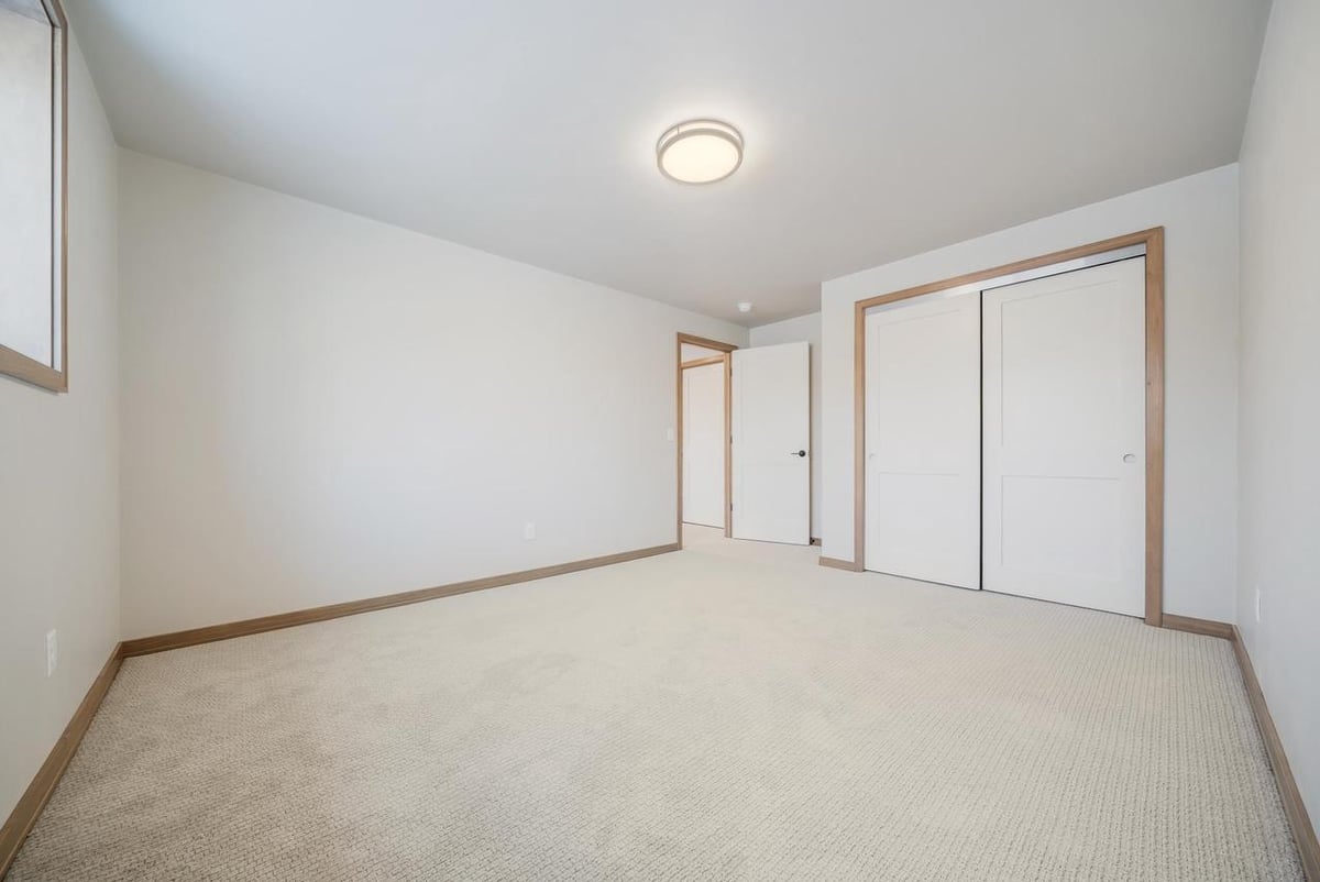 Carpeted bedroom with double closet doors in the Fox Cities