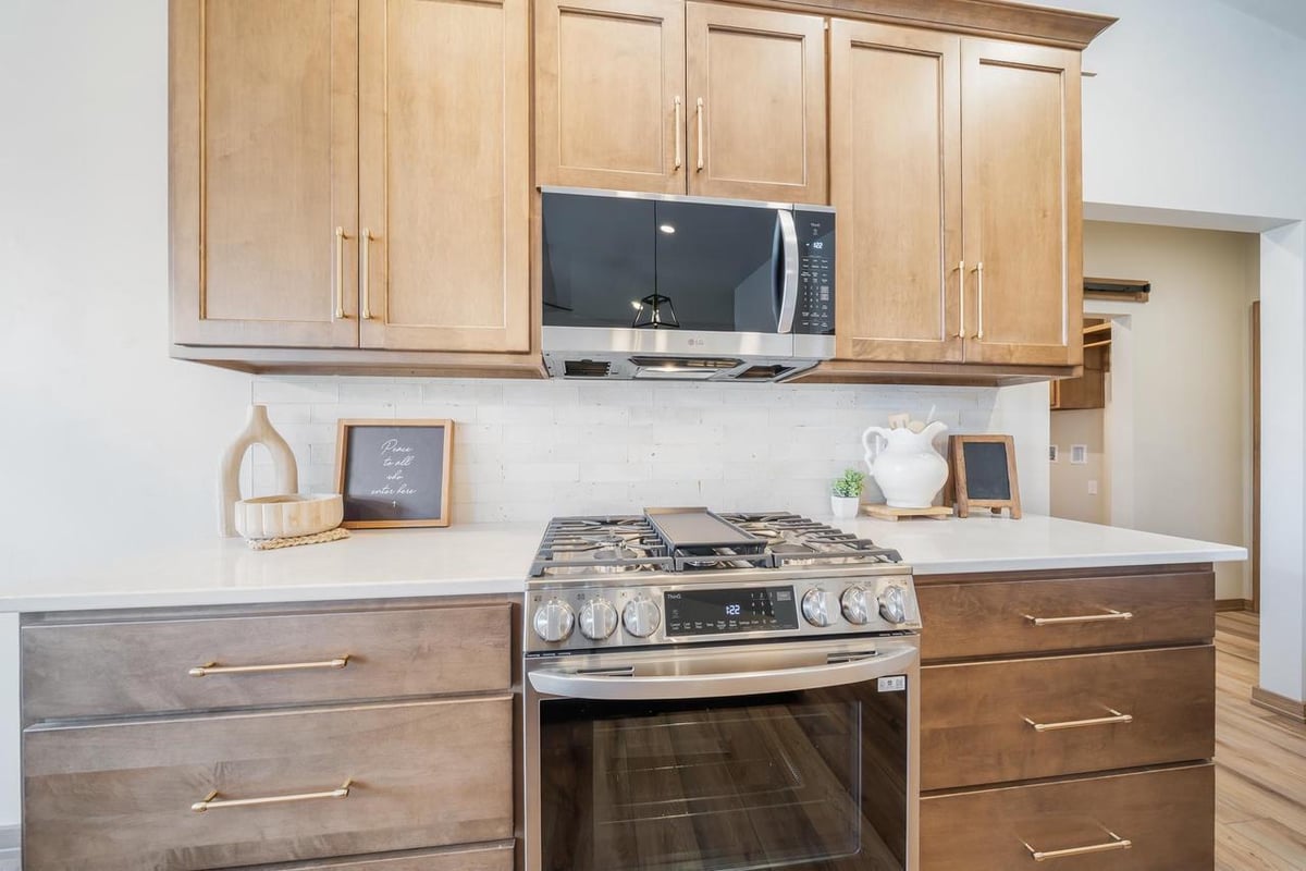 Close-up of gas range, microwave, and wood cabinetry in the Fox Cities kitchen