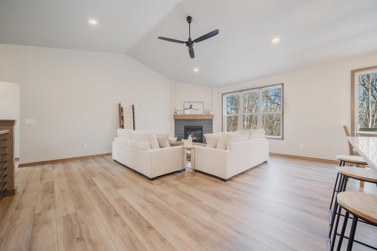 Fox Cities great room with large windows, neutral sofas, and wood-look flooring