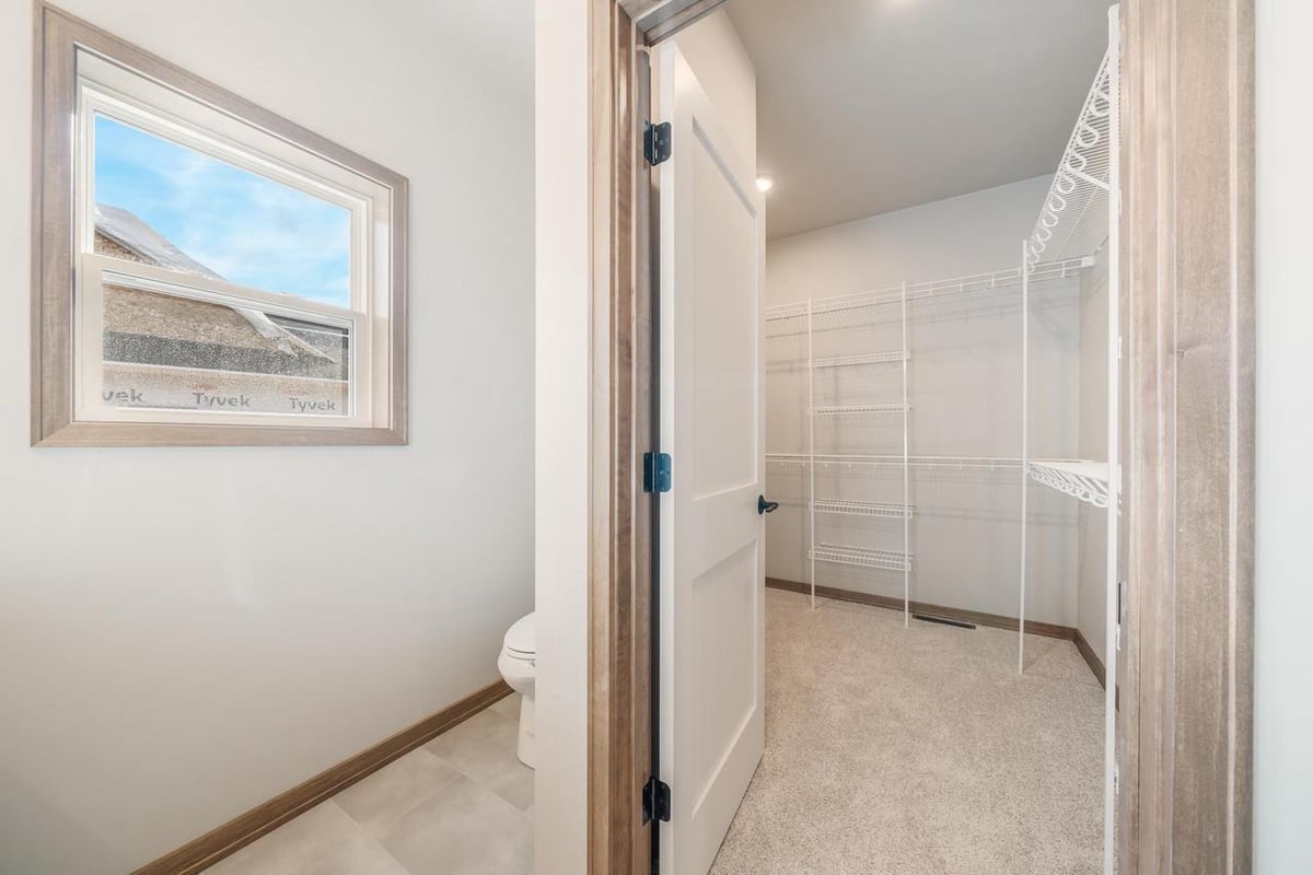 Fox Cities primary suite with walk-in closet and nearby bath, neutral finishes and wood trim