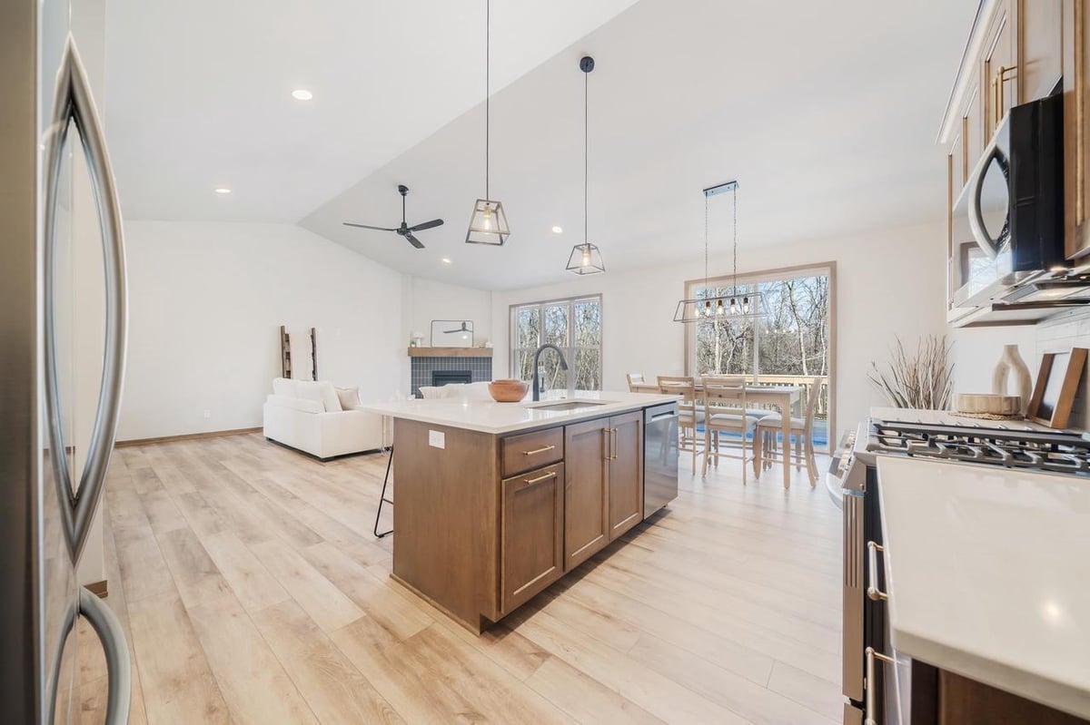 Open kitchen and living area with island, fireplace and deck views in the Fox Cities