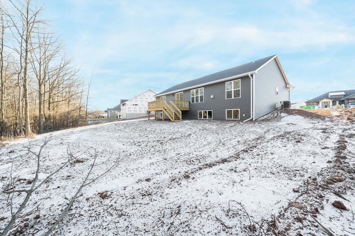 Rear exterior with snowy yard and elevated deck at a Fox Cities home