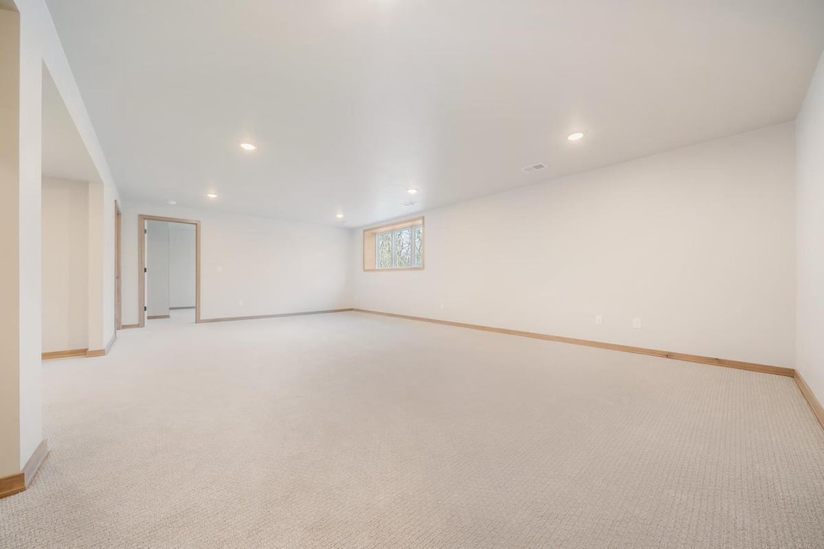 Spacious finished lower level with recessed lighting and egress window in a Fox Cities home