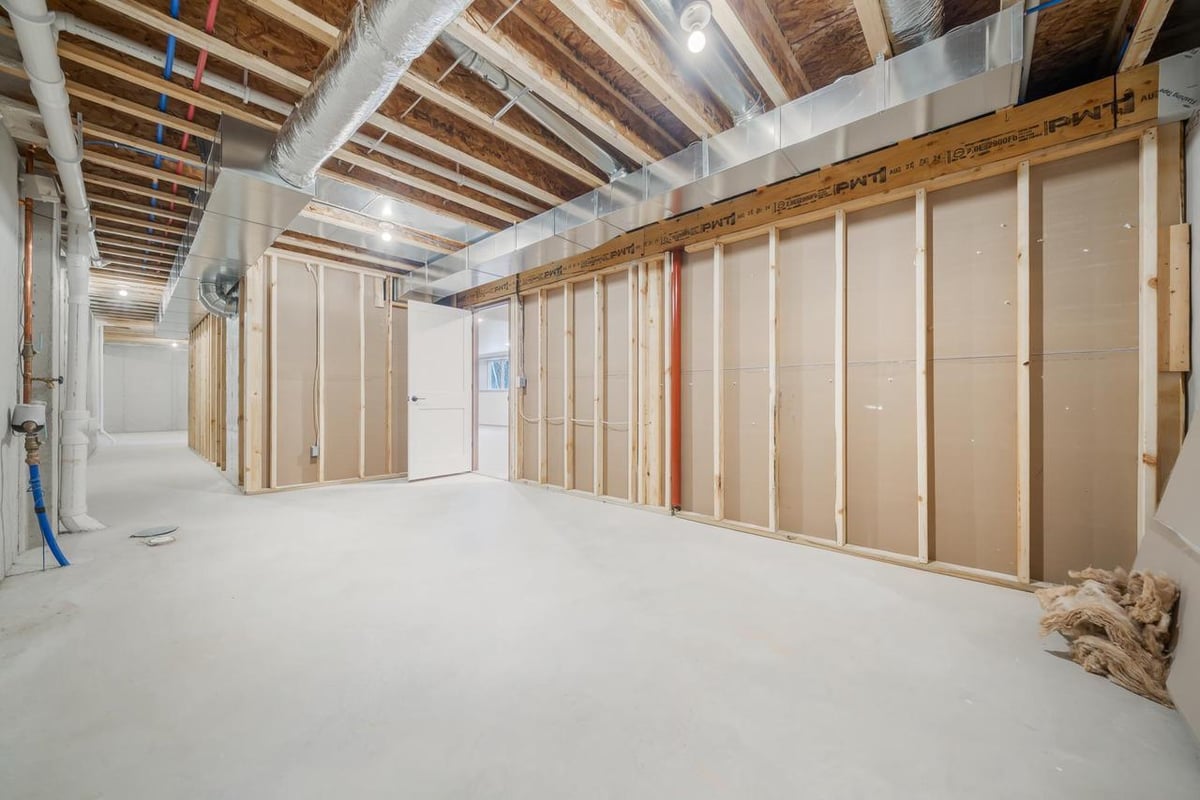 Unfinished basement with exposed framing and ductwork in a Fox Cities home