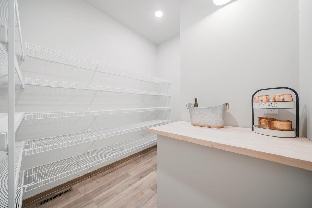 Walk-in pantry with white wire shelving and wood countertop in a Fox Cities home