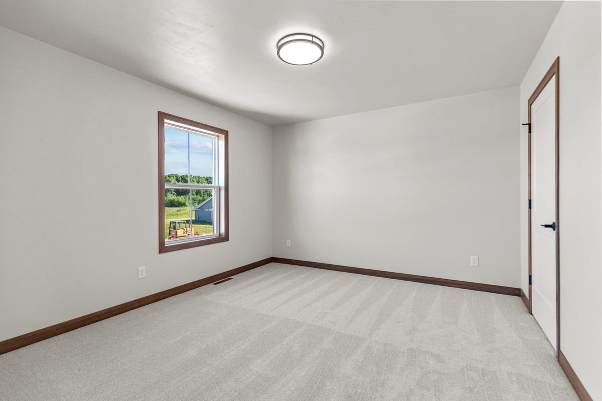 Cozy bedroom space with neutral tones by Midwest Design Homes in Ellington, Wisconsin