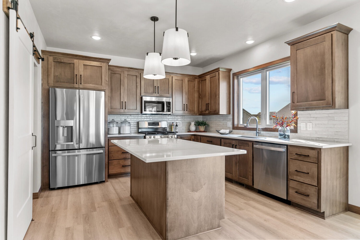 Island-centered kitchen with quartz countertops in custom home by Midwest Design Homes, located in Fox Cities, WI