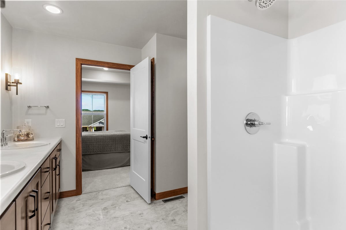 Master bathroom with shower and vanity view into bedroom by Midwest Design Homes in Greenville, WI