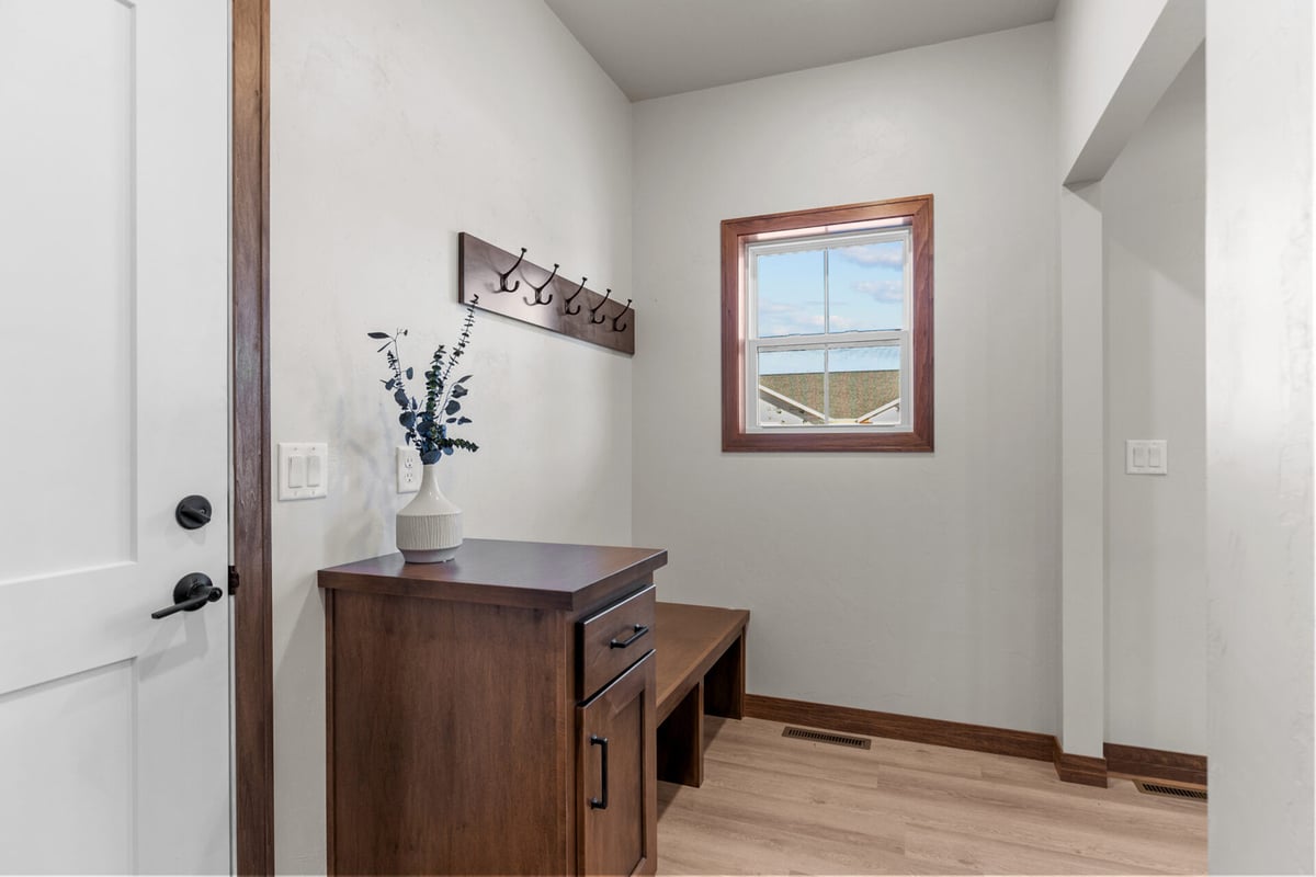 Mudroom area with window, coat hooks, and cabinet space in a custom Appleton, WI home by Midwest Design Homes