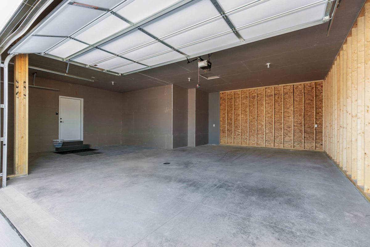 Spacious unfinished garage interior of a custom home in Appleton, WI built by Midwest Design Homes