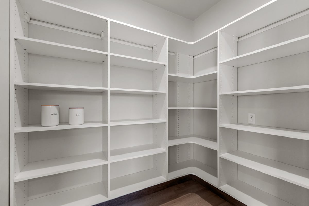 Spacious walk-in pantry with white shelving in a custom Fremont, WI home by Midwest Design Homes