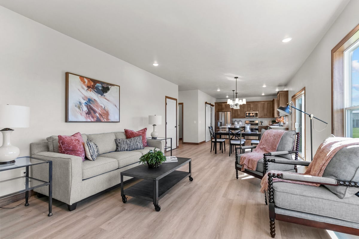 View of custom-built dining room flowing into cozy living room in Neenah, WI by Midwest Design Homes