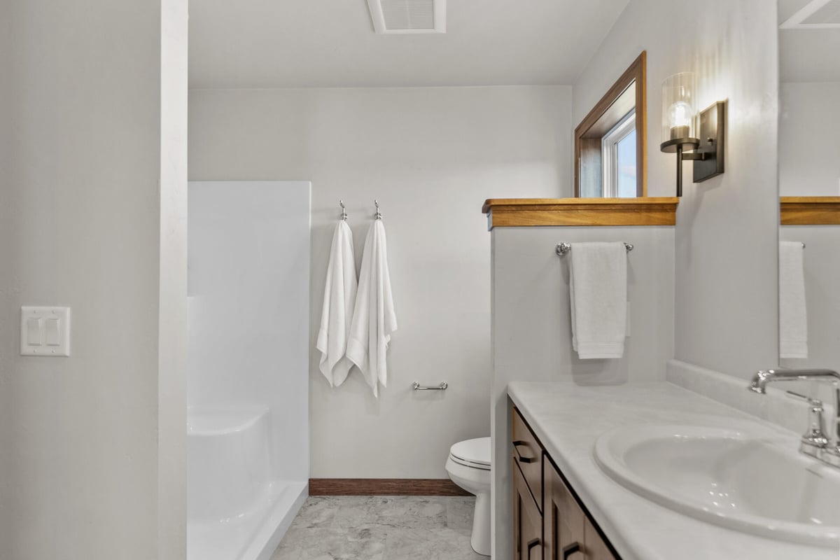 Walk-in shower and towel hooks in primary bathroom by Midwest Design Homes in Kaukauna, WI