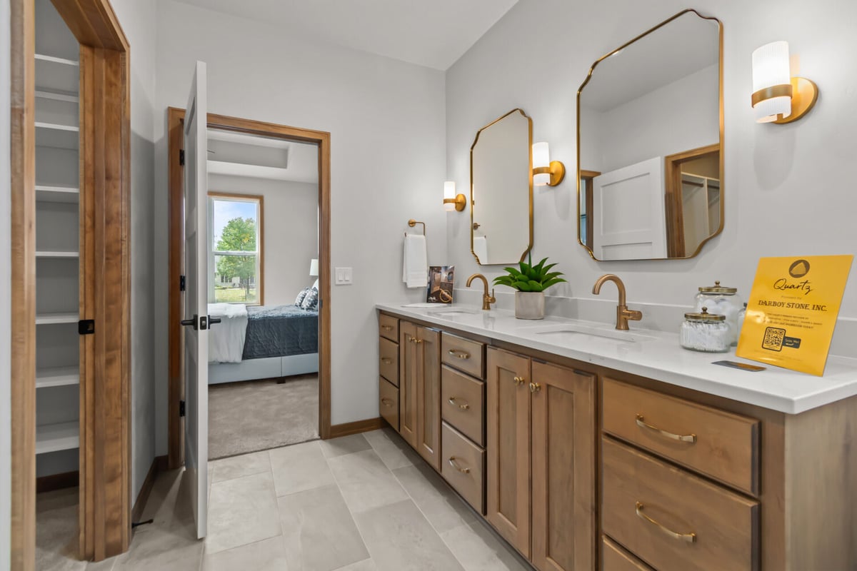 Alternate angle of dual vanity bathroom with warm wood finishes in Neenah, WI by Midwest Design Homes