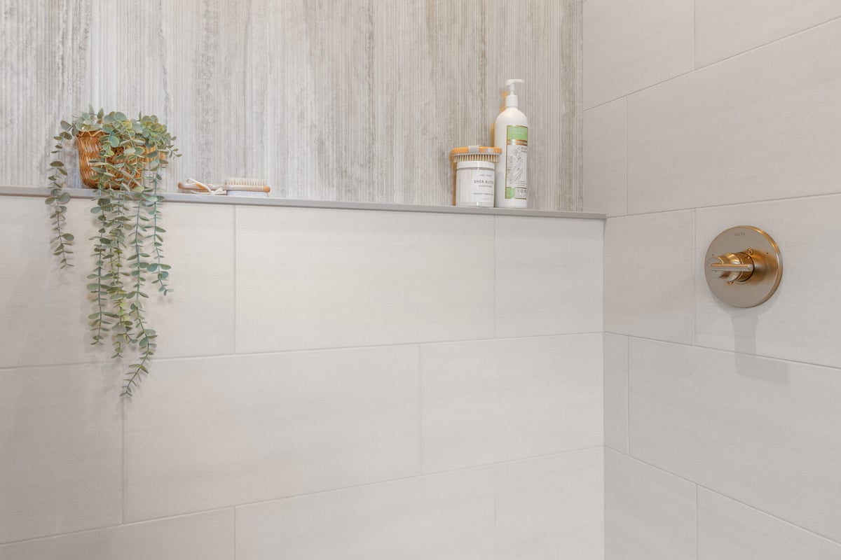 Built-in shower shelf with bath products and plant decor in Kaukauna, WI by Midwest Design Homes
