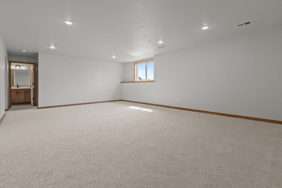 Finished basement with bathroom access and bright window in Neenah, WI by Midwest Design Homes