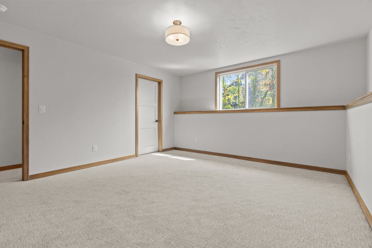 Finished lower-level bedroom with egress window in Harrison, WI by Midwest Design Homes
