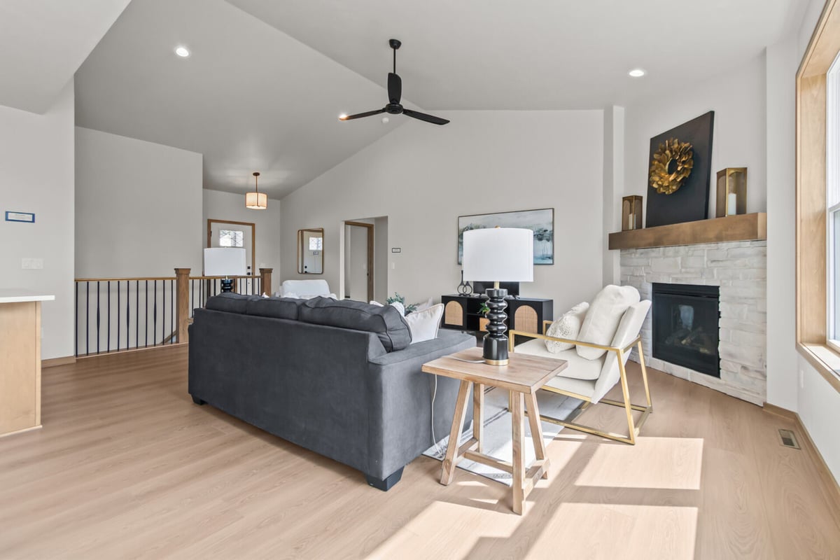 Vaulted ceiling living room with fireplace and modern furnishings in a custom home by Midwest Design Homes in Kaukauna, WI