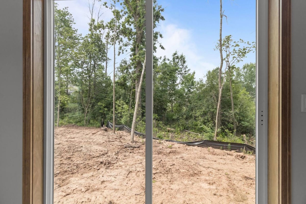 Backyard view from bedroom window showing wooded lot in a Fremont, WI custom home by Midwest Design Homes